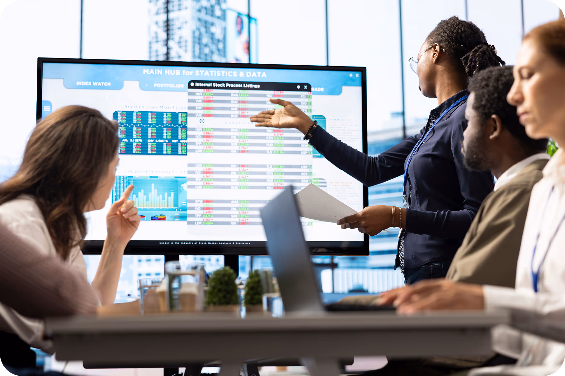 Due mani che tengono un foglio con grafici e una penna sulla tastiera di un laptop.