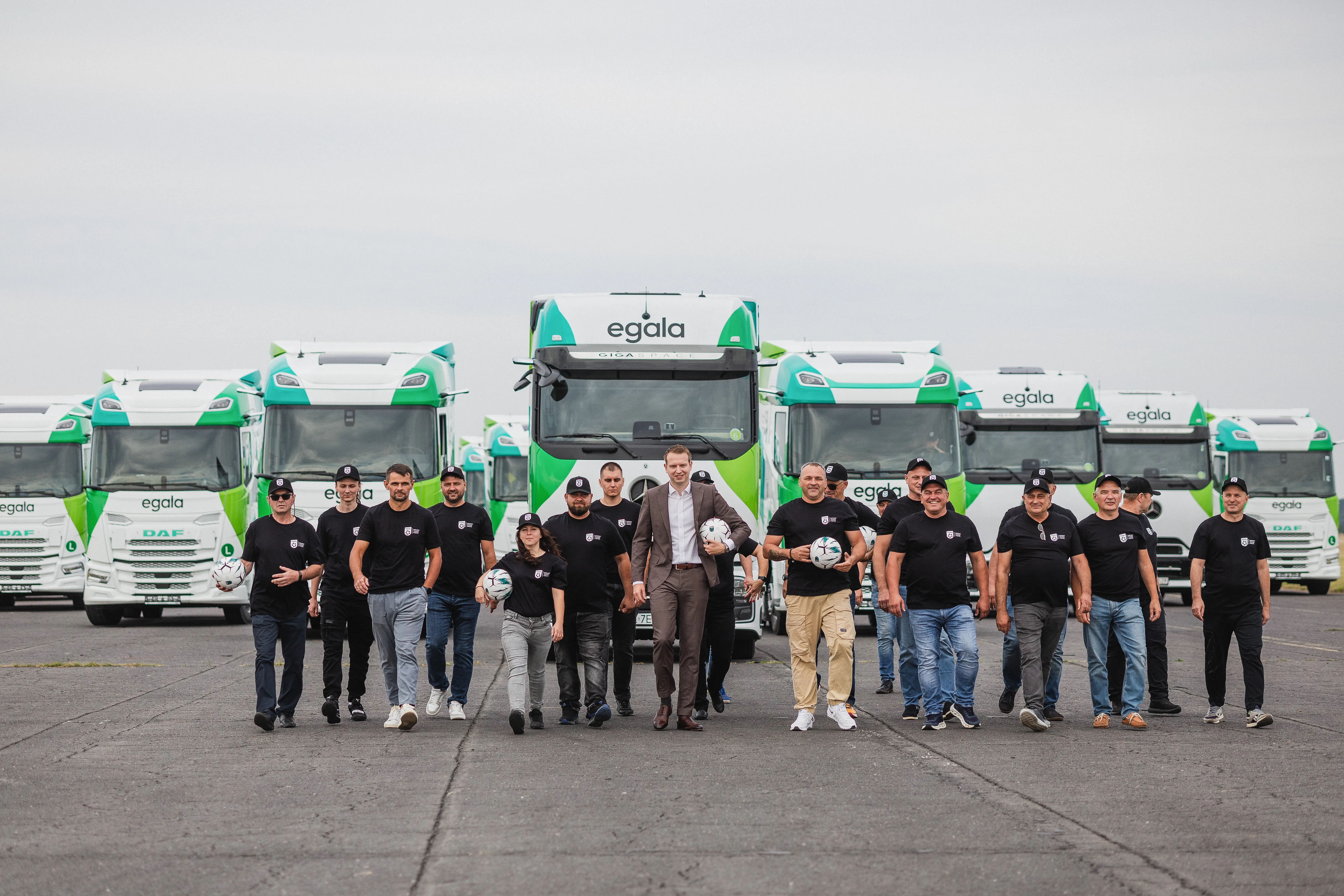 Current CEO of Egala standing with company drivers, representing teamwork and commitment to the future of transport.