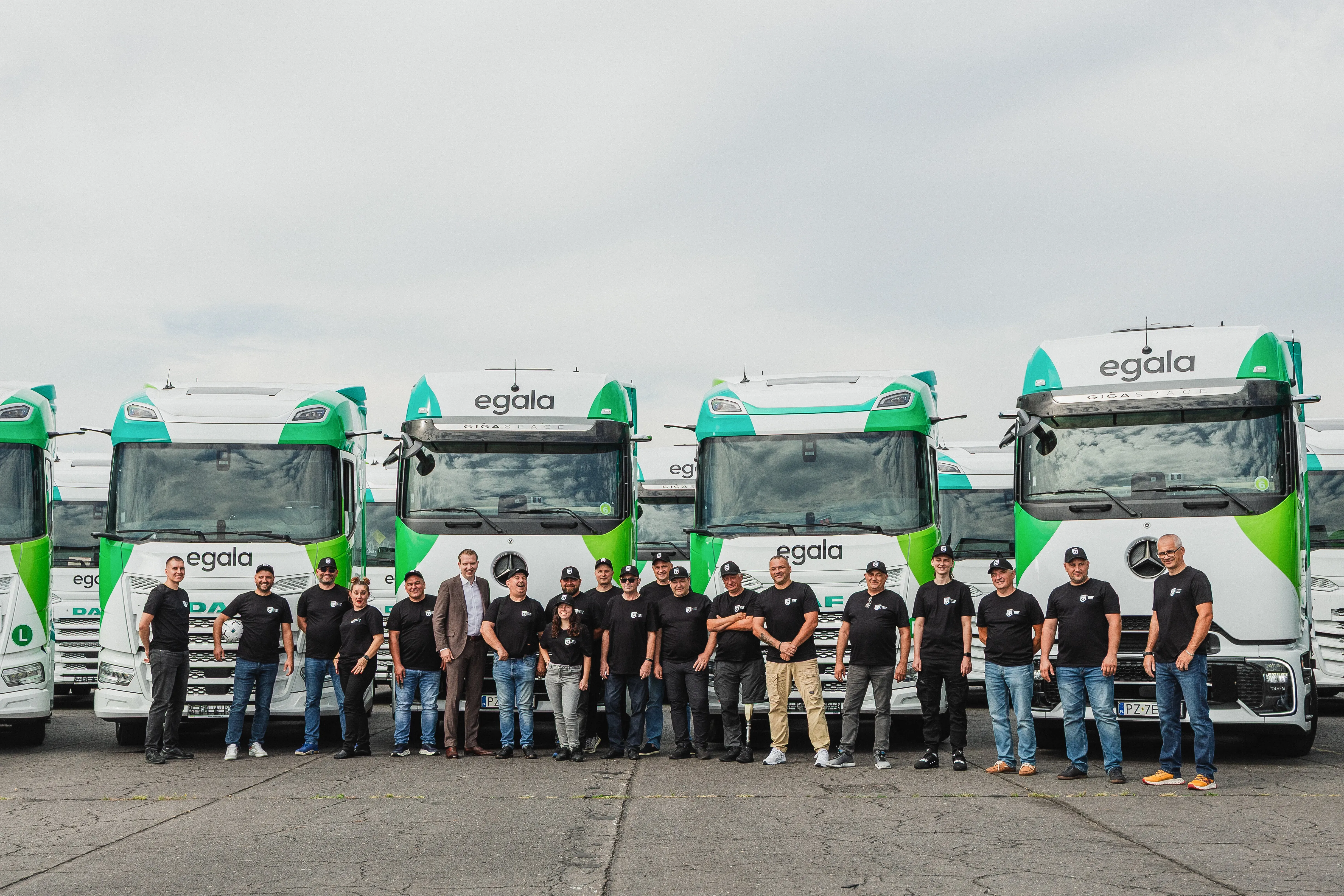 Group of Egala by Boekestijn team members posing together in front of several company trucks.