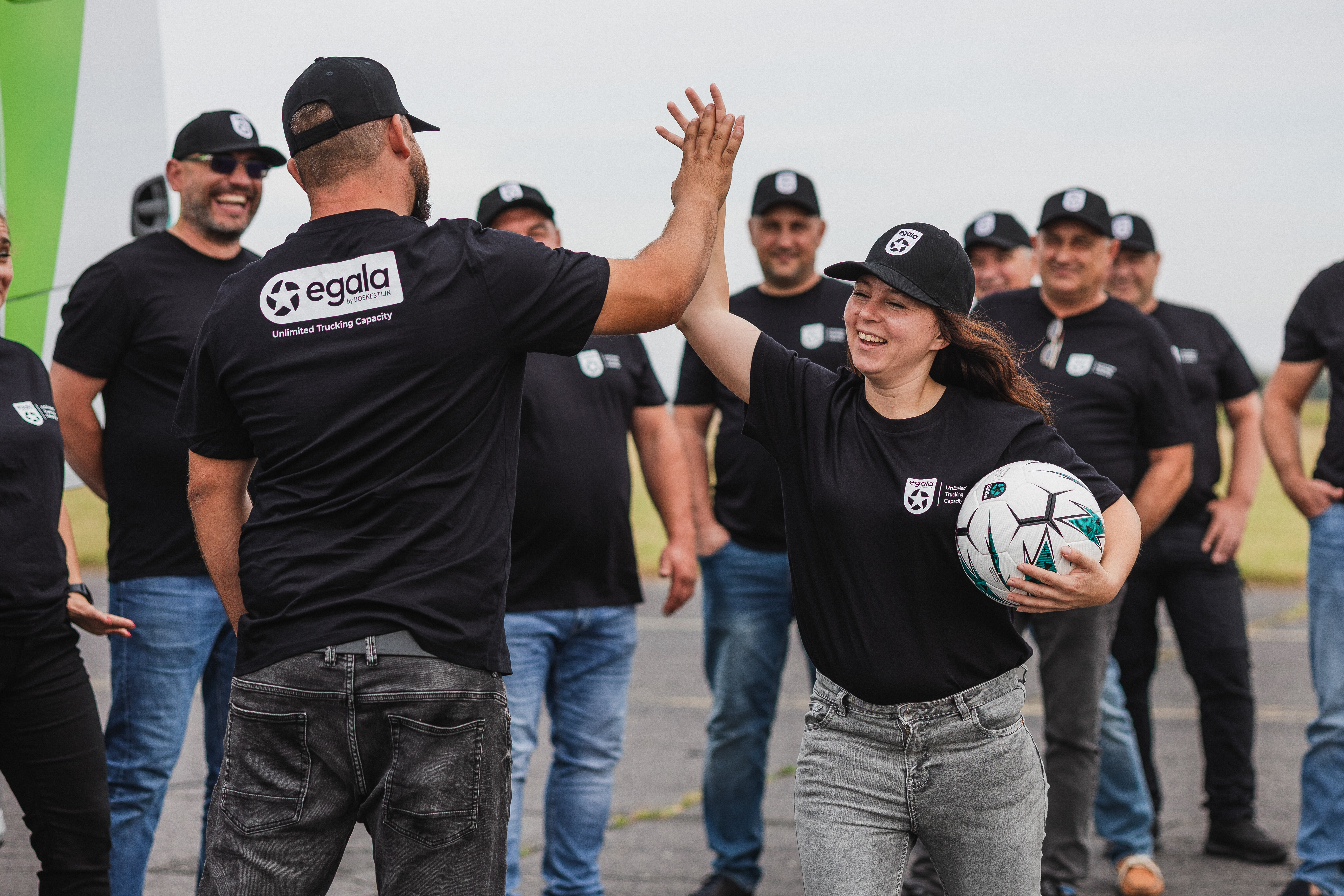 Group of Egala by Boekestijn team members standing together, seen from behind, wearing branded shirts.