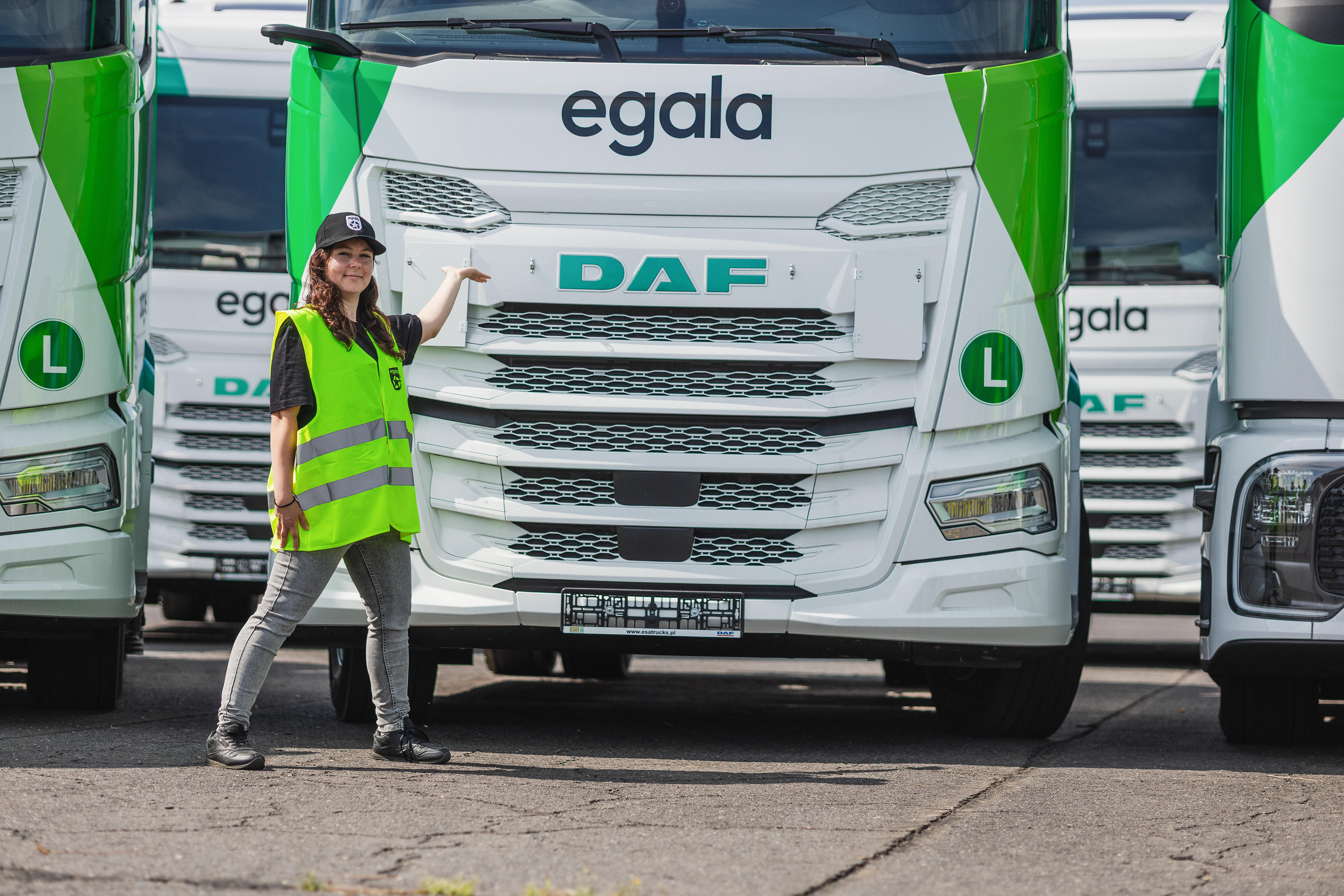 Egala by Boekestijn female truck driver standing proudly in front of DAF trucks — representing the High Wheels program supporting women in trucking