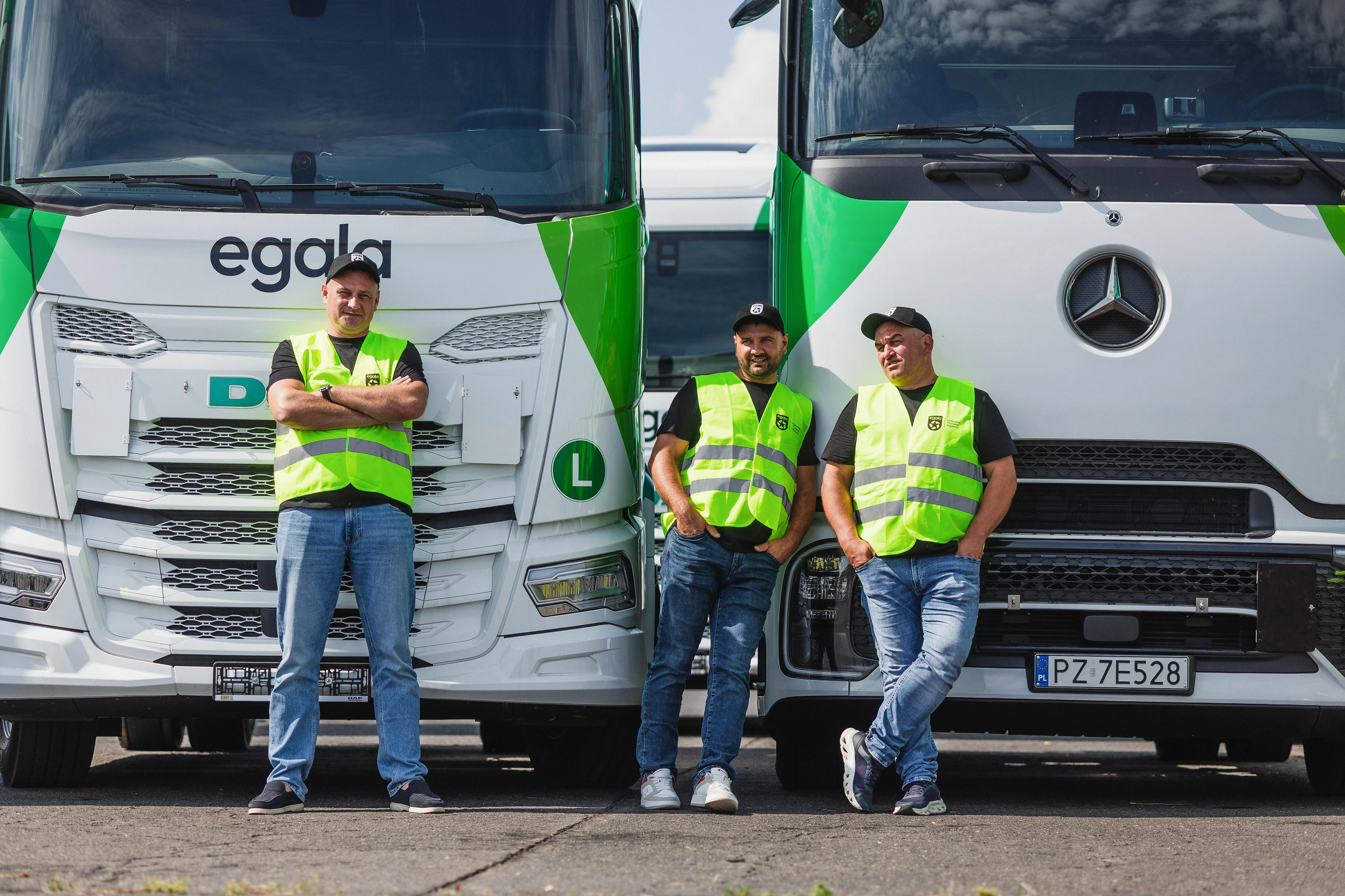 Egala by Boekestijn truck drivers in high-visibility vests standing in front of DAF and Mercedes trucks — representing safety, professionalism, and pride in European trucking