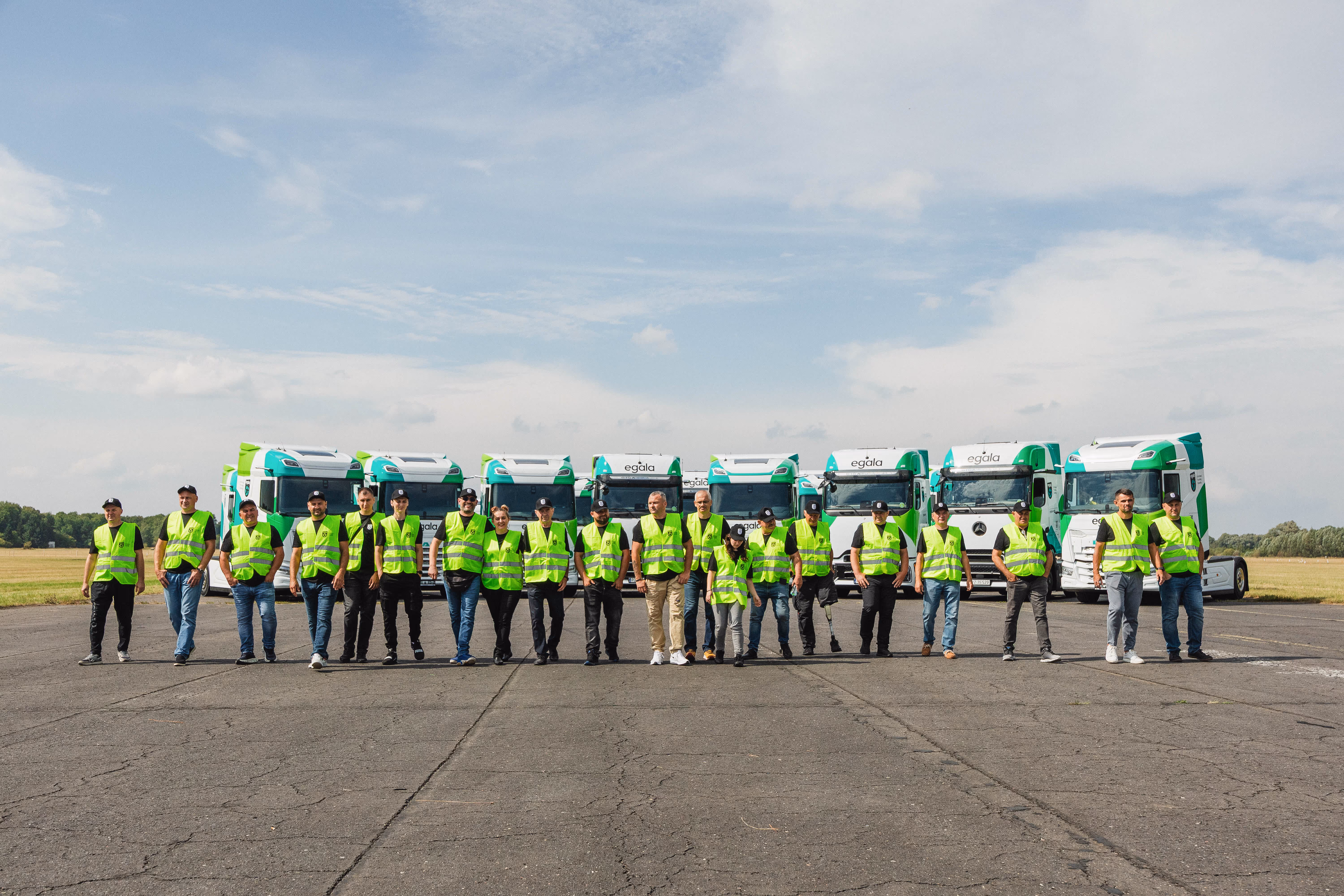 Egala by Boekestijn trucking team in high-visibility vests standing in front of green and white DAF trucks — symbolizing unity, safety, and commitment to excellence in European trucking
