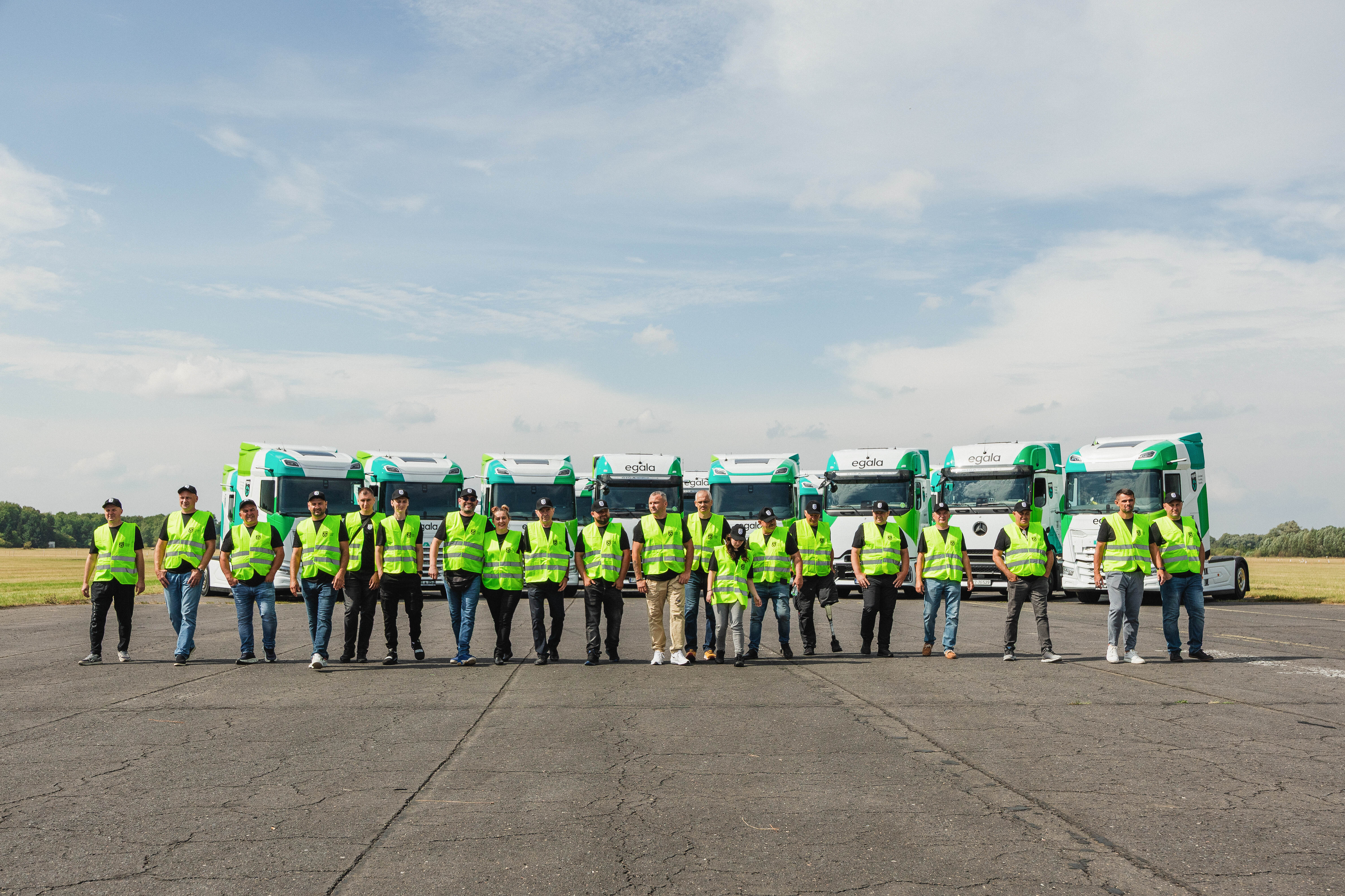 Egala by Boekestijn trucking team in high-visibility vests standing in front of green and white DAF trucks — symbolizing unity, safety, and commitment to excellence in European trucking