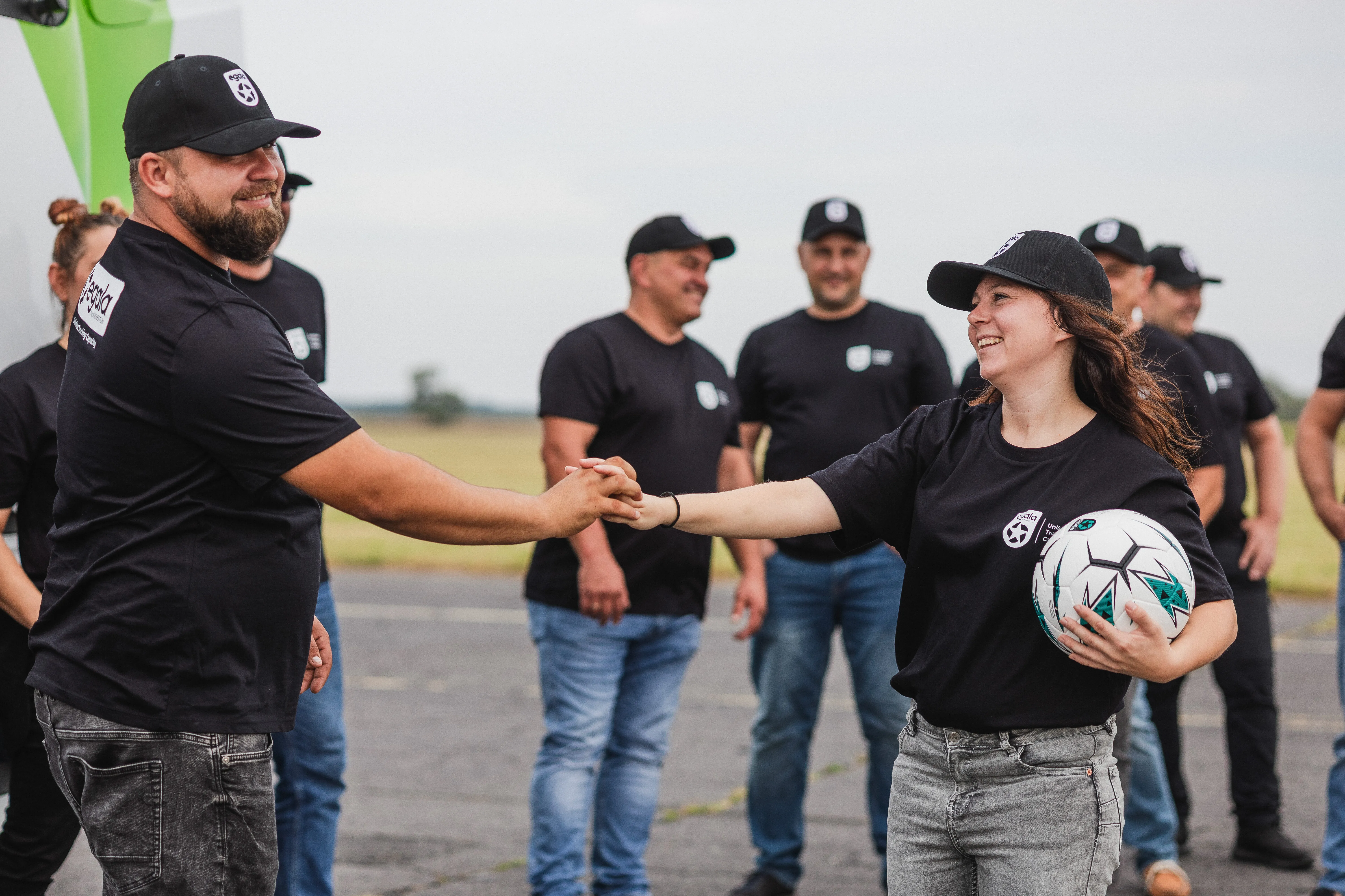 Egala by Boekestijn team members smiling and shaking hands during a company event — symbolizing teamwork, respect, and a strong company culture in trucking