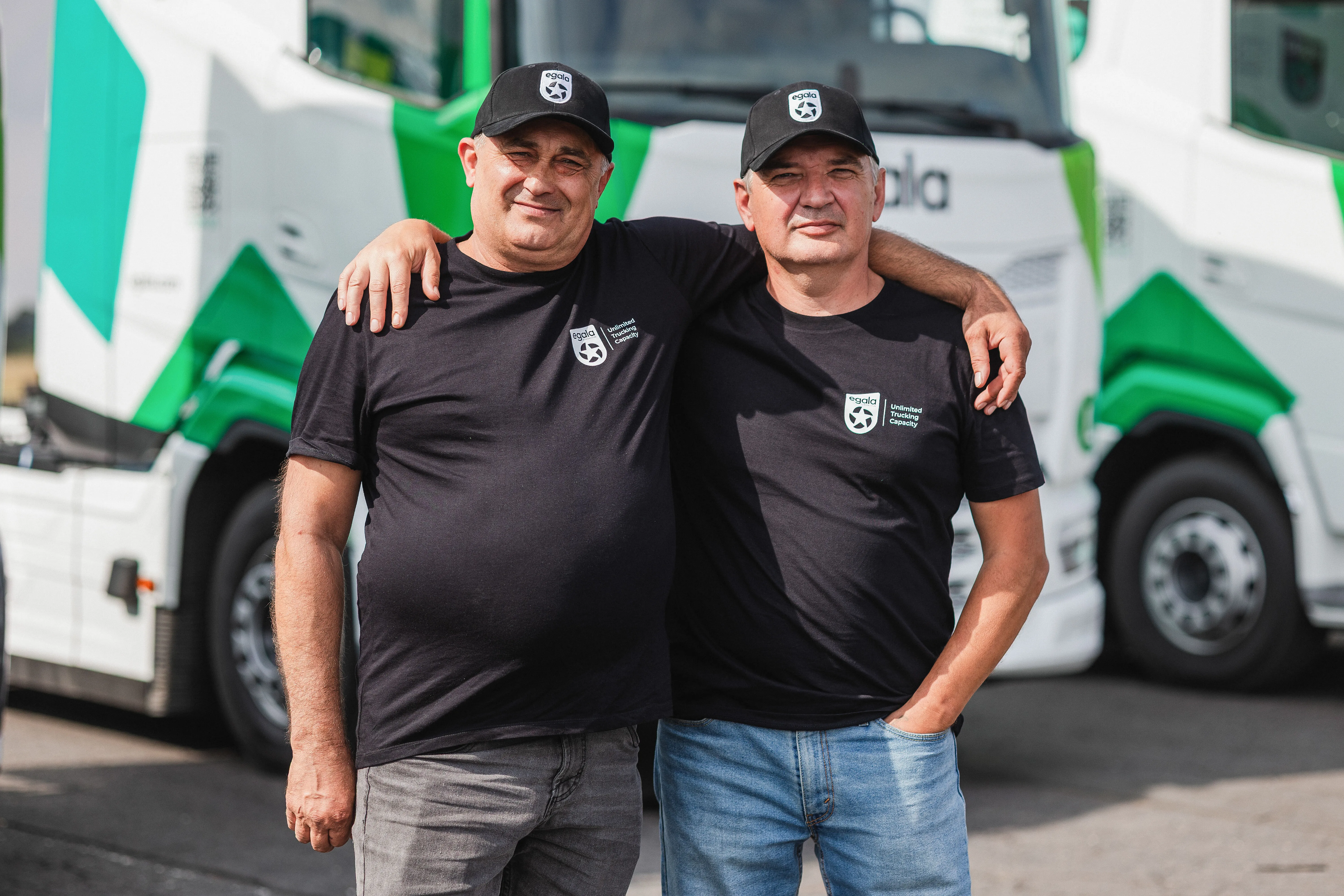 Two Egala by Boekestijn drivers standing close together and smiling in front of a truck.