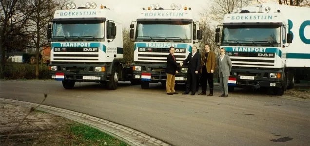 Archival photograph of Boekestijn Transport founders standing in front of early company trucks.