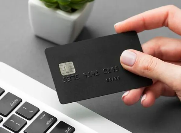 Hand holding a sleek black payment card on a modern office desk, representing Egala by Boekestijn’s efficient and secure transport payment solutions