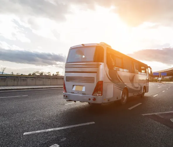 Comfortable company bus on the highway at sunrise, representing Egala by Boekestijn’s free employee transport to and from work.