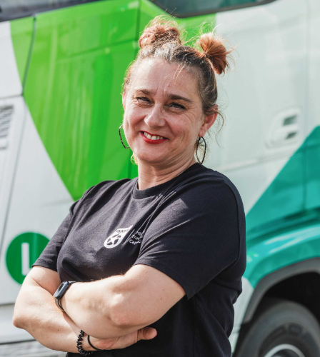 Egala team member smiling in front of a truck — representing inclusion and diversity in European trucking