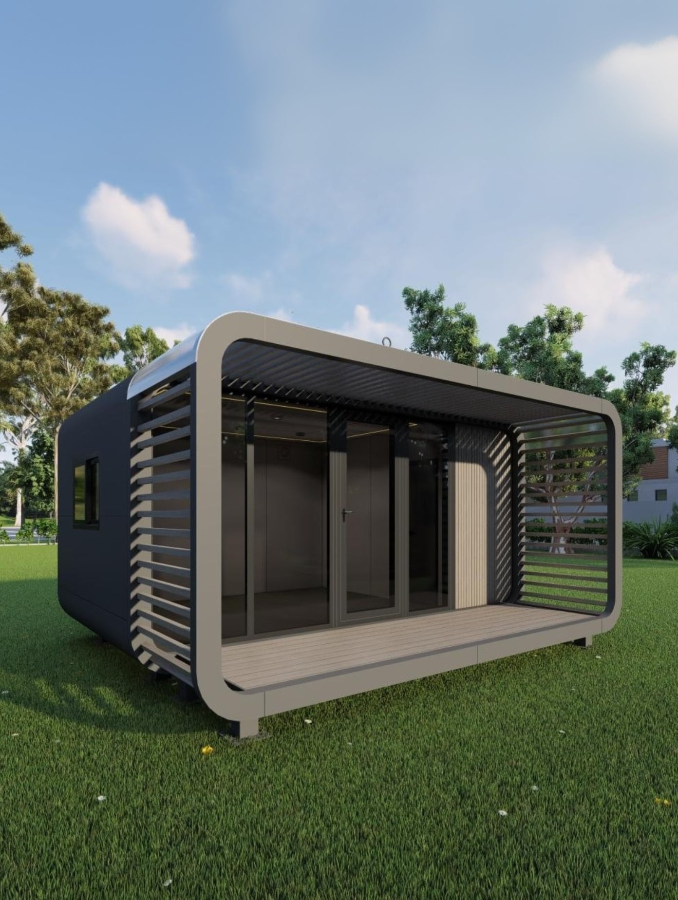 Modern, compact cabin with large glass doors and a shaded porch sitting on green grass with trees in the background under a blue sky.