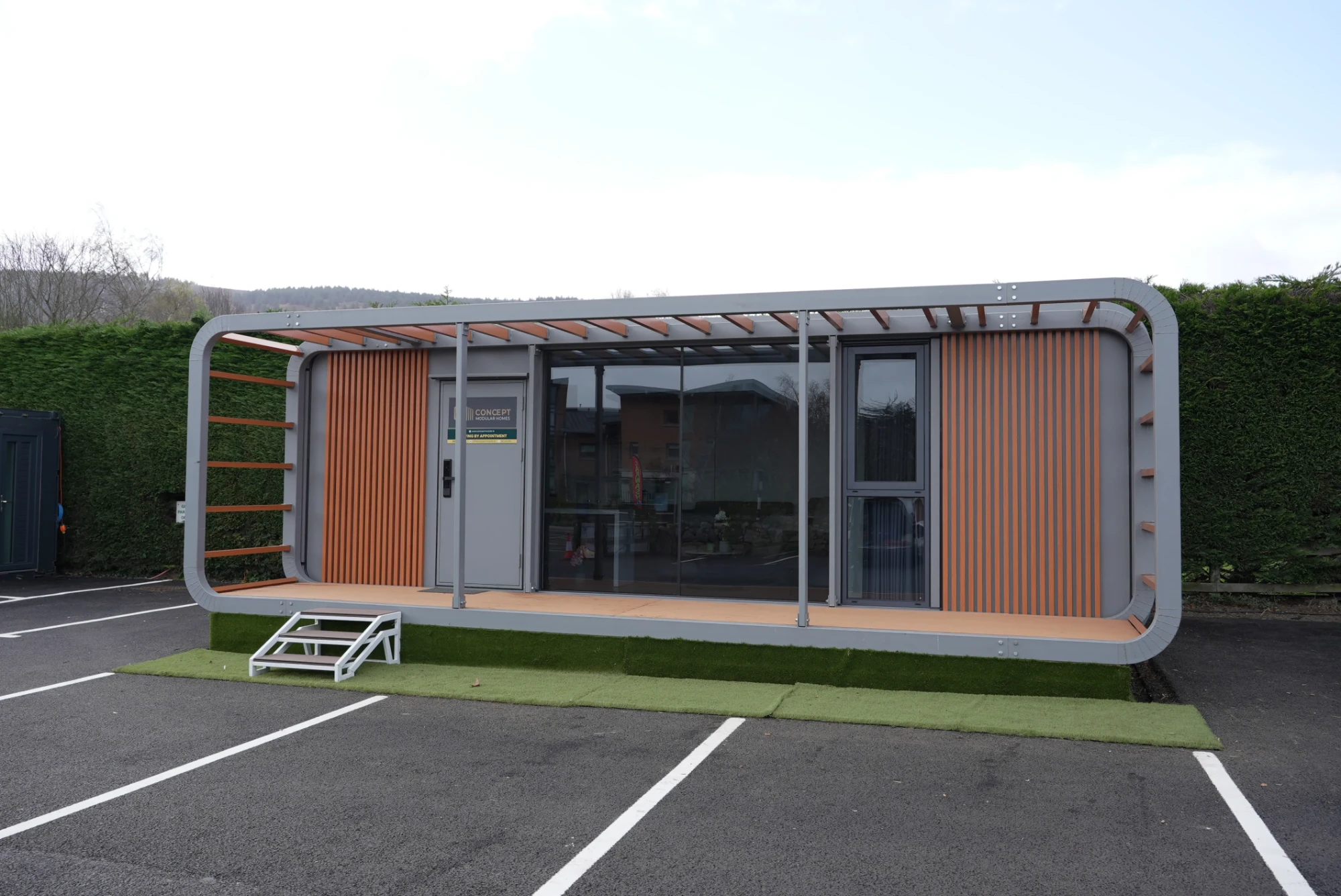 Concept Modular show unit front view with glass frontage, timber-effect cladding and covered terrace