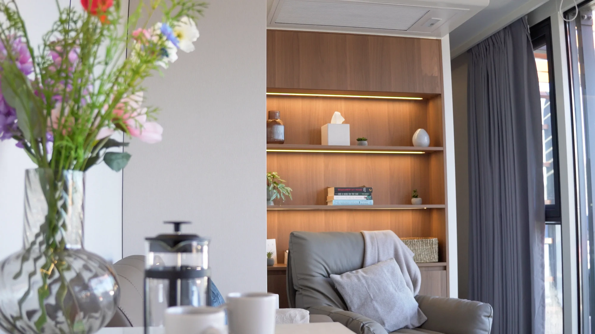Concept Modular interior with lit timber shelving, lounge chair and coffee table