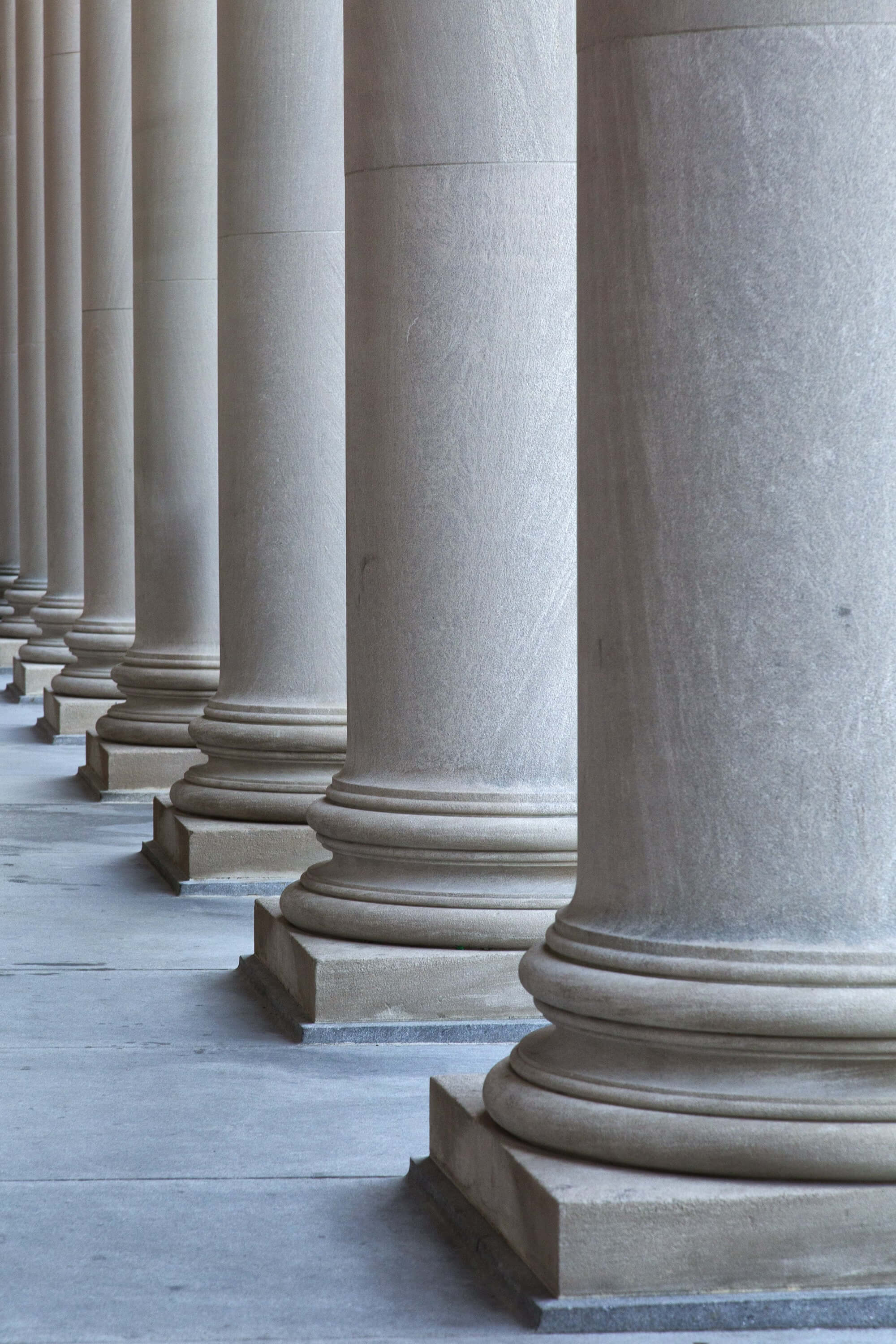 Classical stone columns aligned in perspective, symbolizing strength and stability—ideal for ASAM legal’s professional branding.