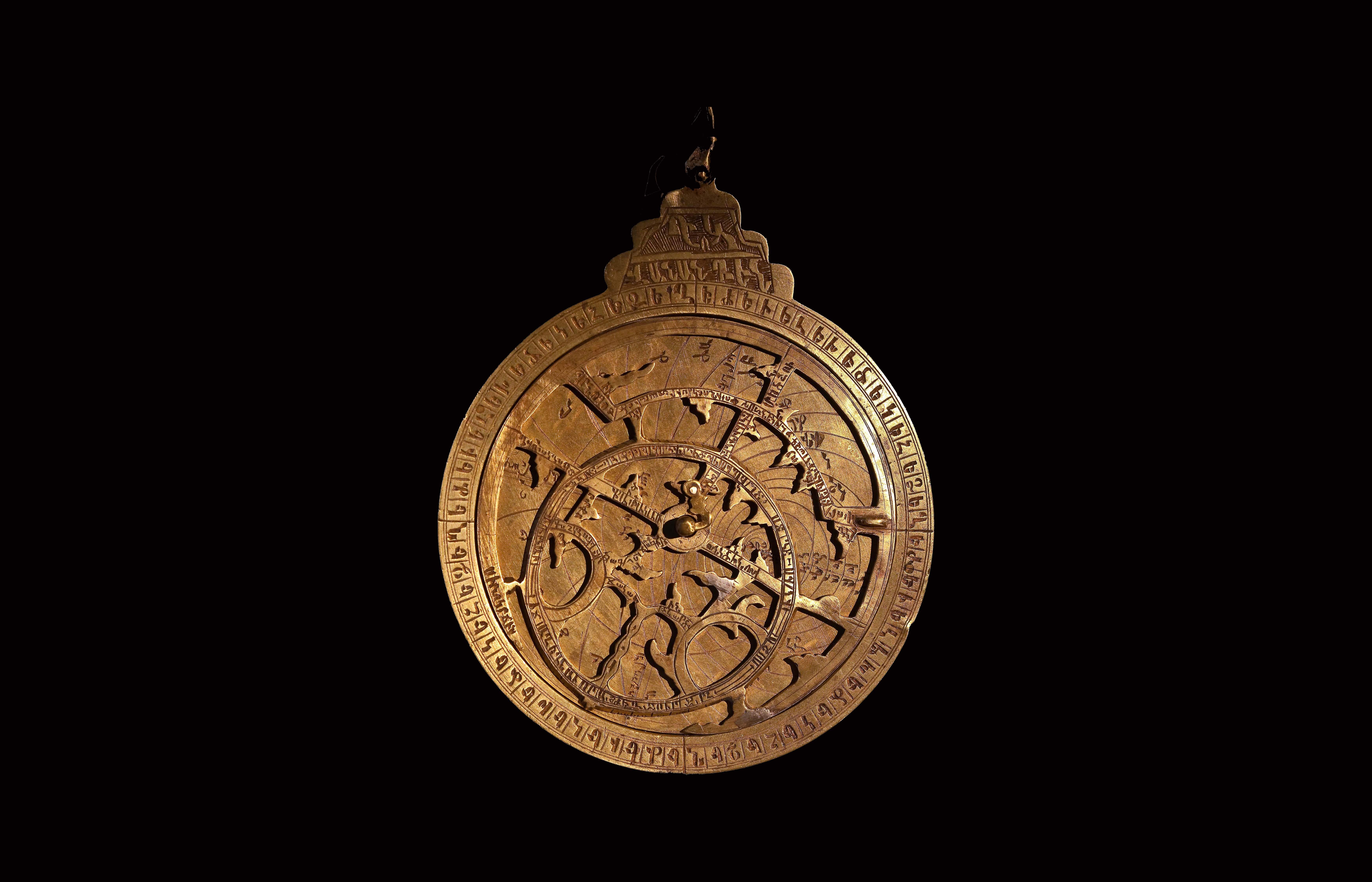 Brass astrolabe with engraved scales and rotating star map, symbolizing ancient astronomy, precision, and scientific heritage.