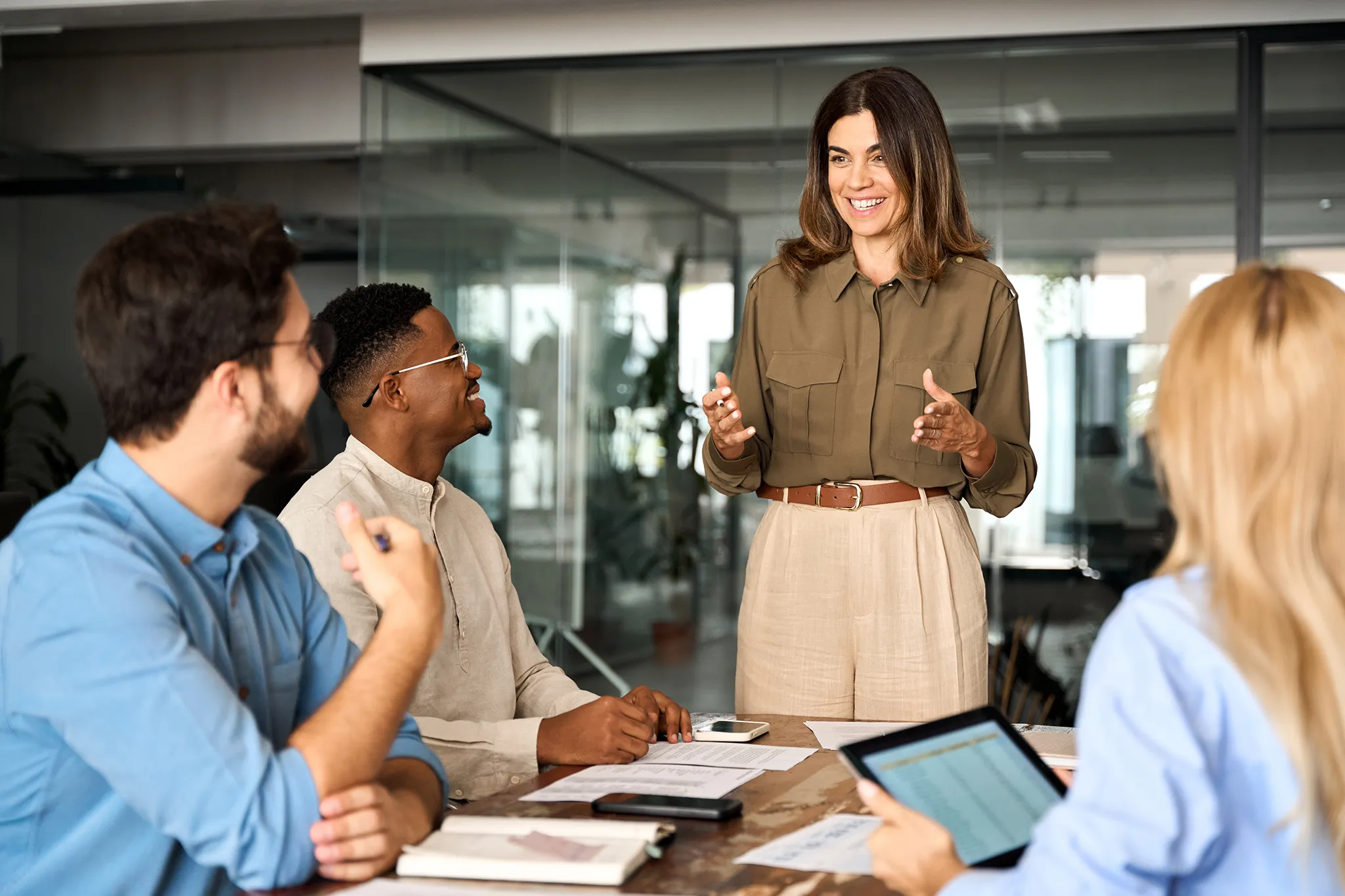 Smiling businesswoman in meeting with staff members in office, beside text on PIB's company values