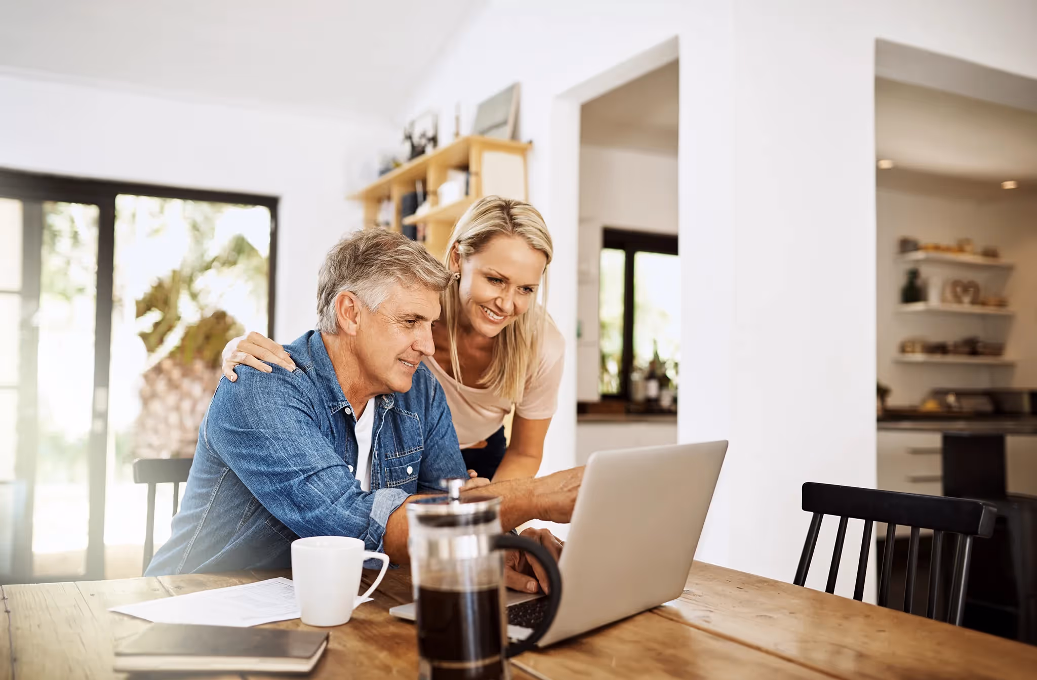 Mature couple reviewing their financial plan and performance on their laptop in their living room