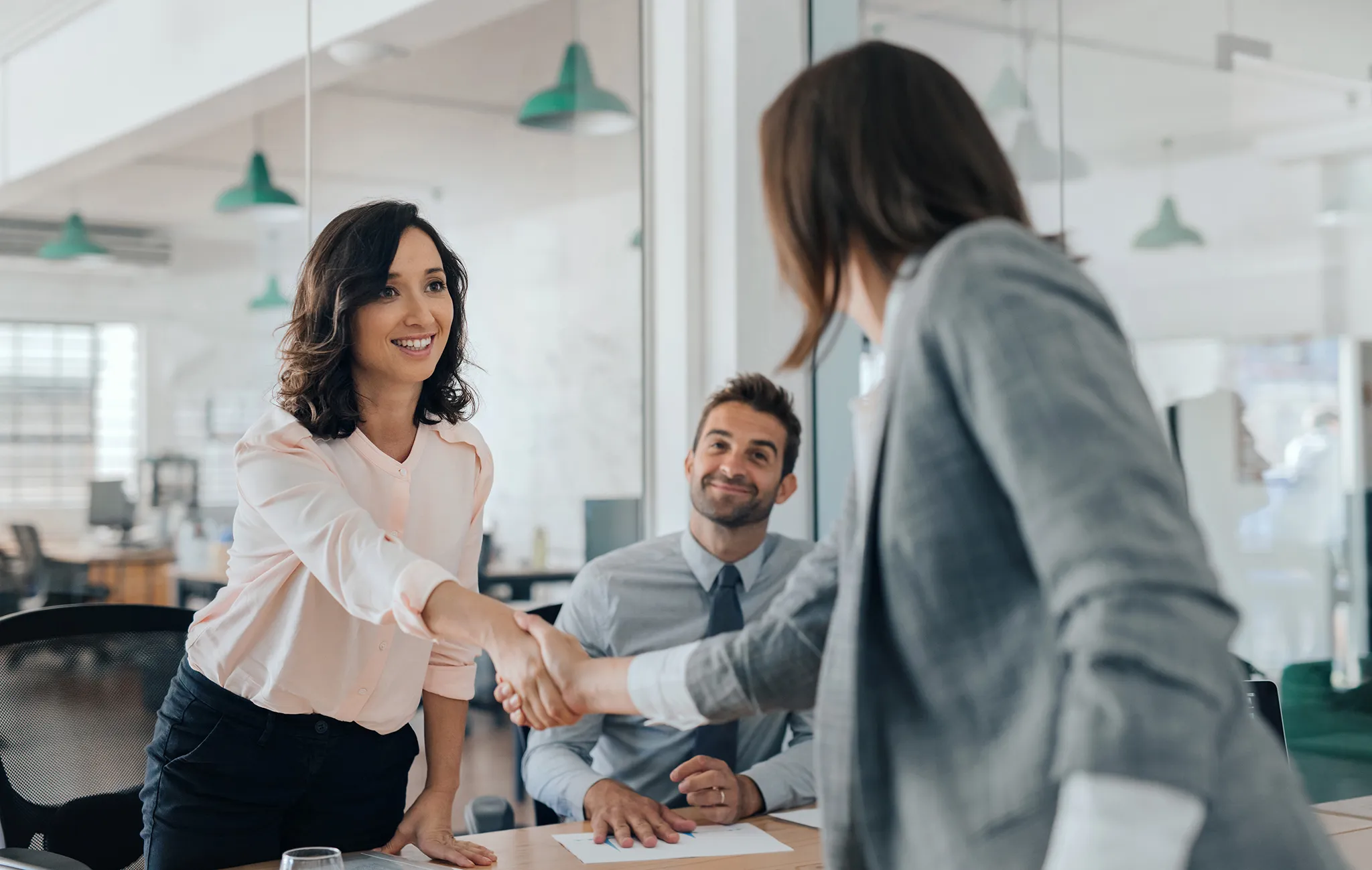 PIB Advisor shaking hands with her client in office environment