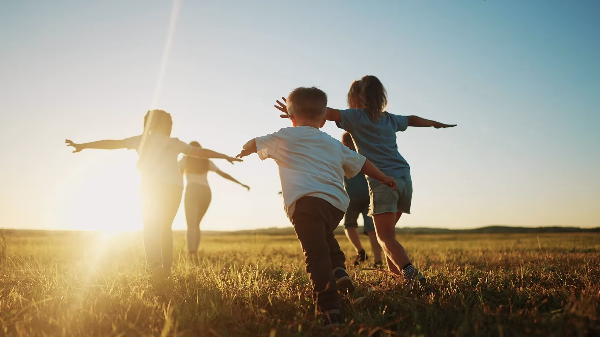 Four children running with arms outstretched in field at sunset with text Kidnap, Ransom, Cyber and Special Contingency