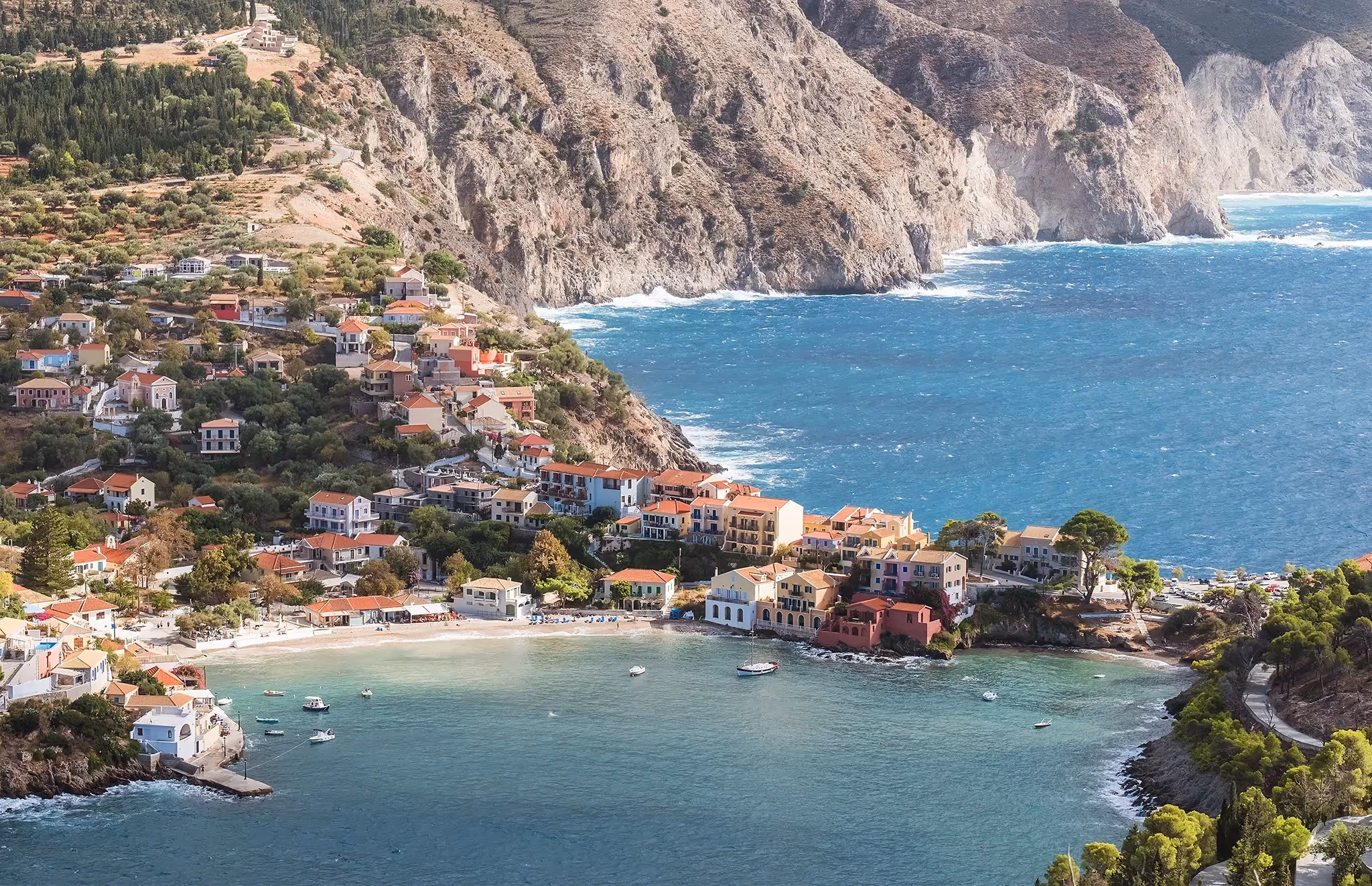 Greek coastline with fishing village in foreground with text Travel Insurance