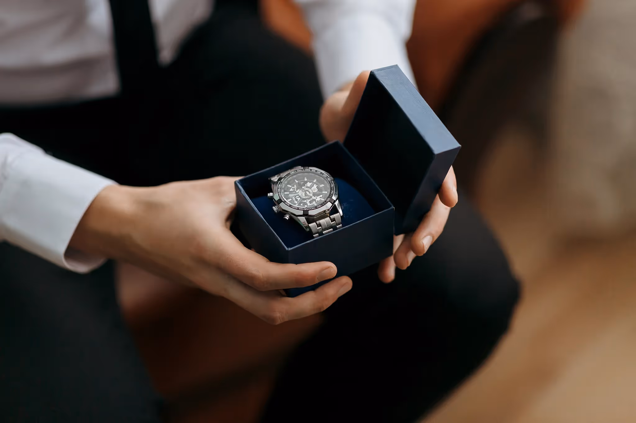 Man holding an expensive wristwatch in a gift box