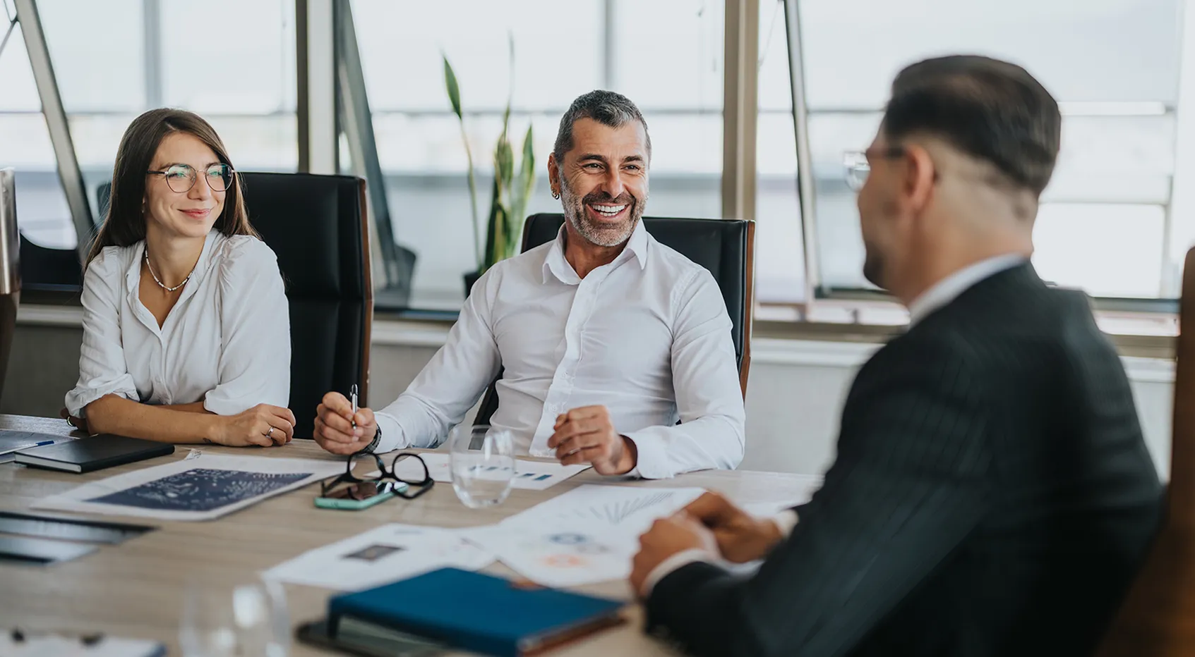 A trio of professionals meeting in a boardroom with text Wealth Management Team