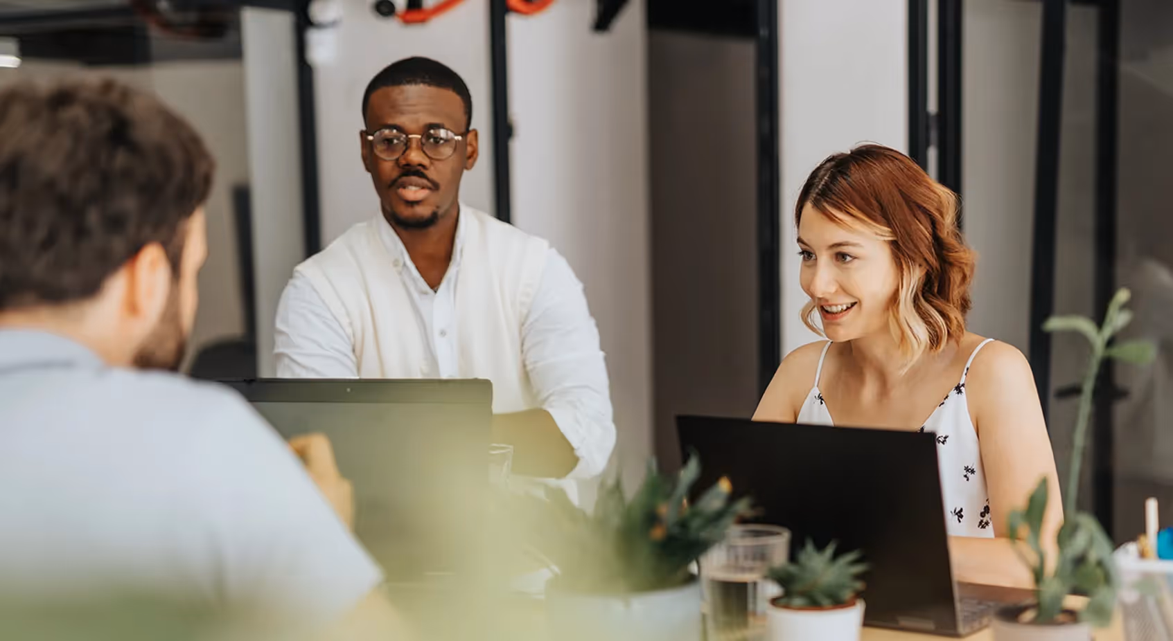 A pair of business people meeting with a client in an office with text Business Insurance Team