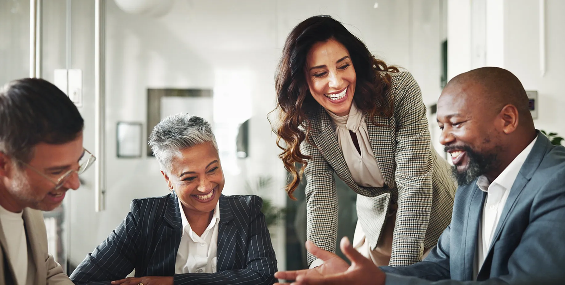 Une équipe souriante de gens d'affaires se concentrant sur les besoins de retraite collective de leurs clients avec le texte Équipe de retraite collective