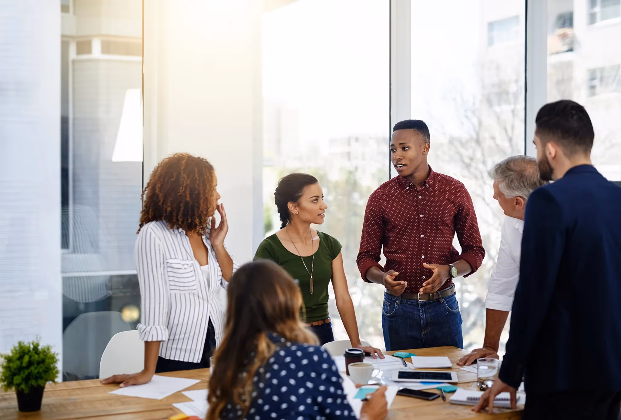 A group of businesspeople standing around a table having a collaborative meeting