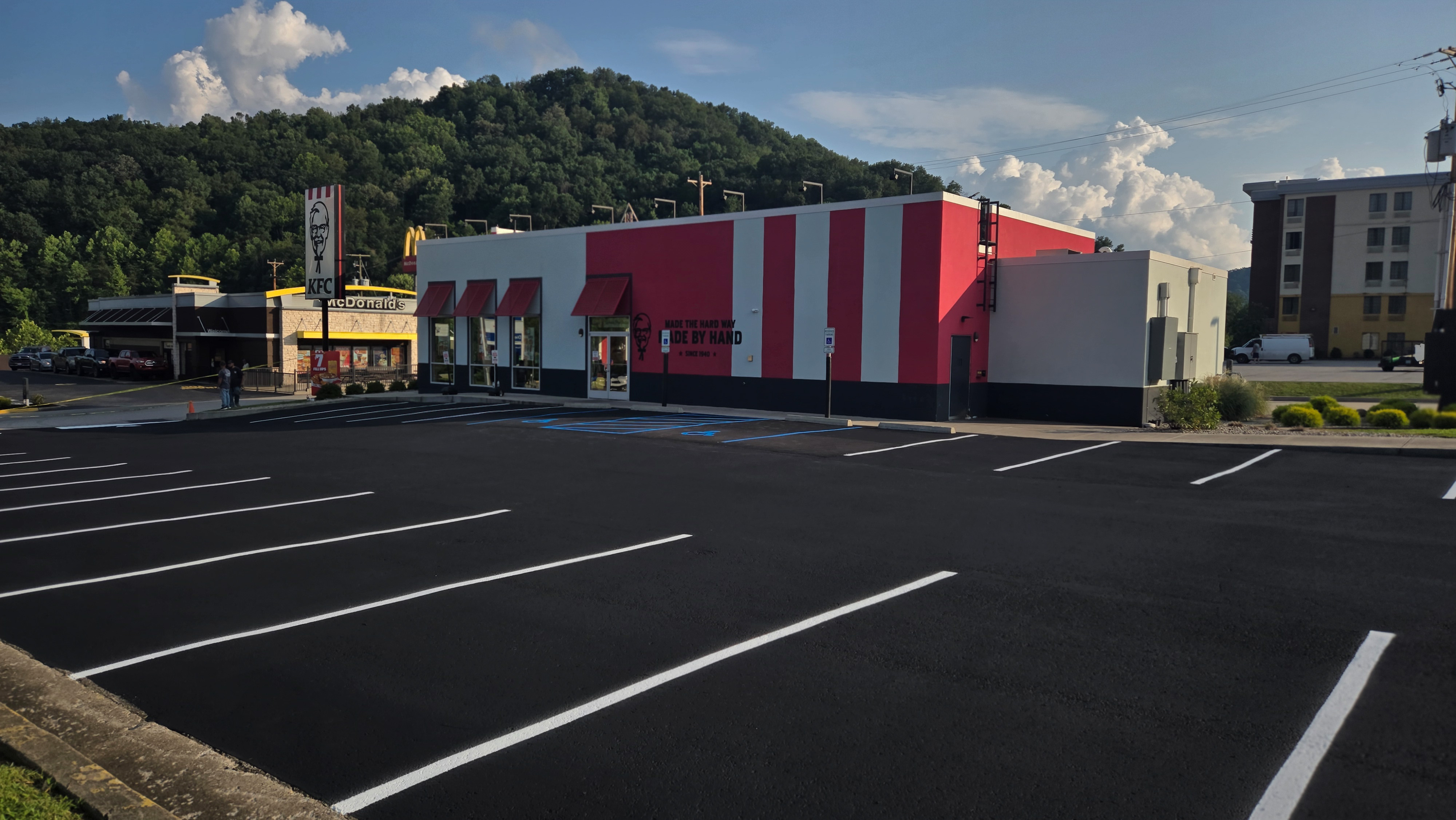 A paved parking lot in front of a Kentucky Fried Chicken restaurant.
