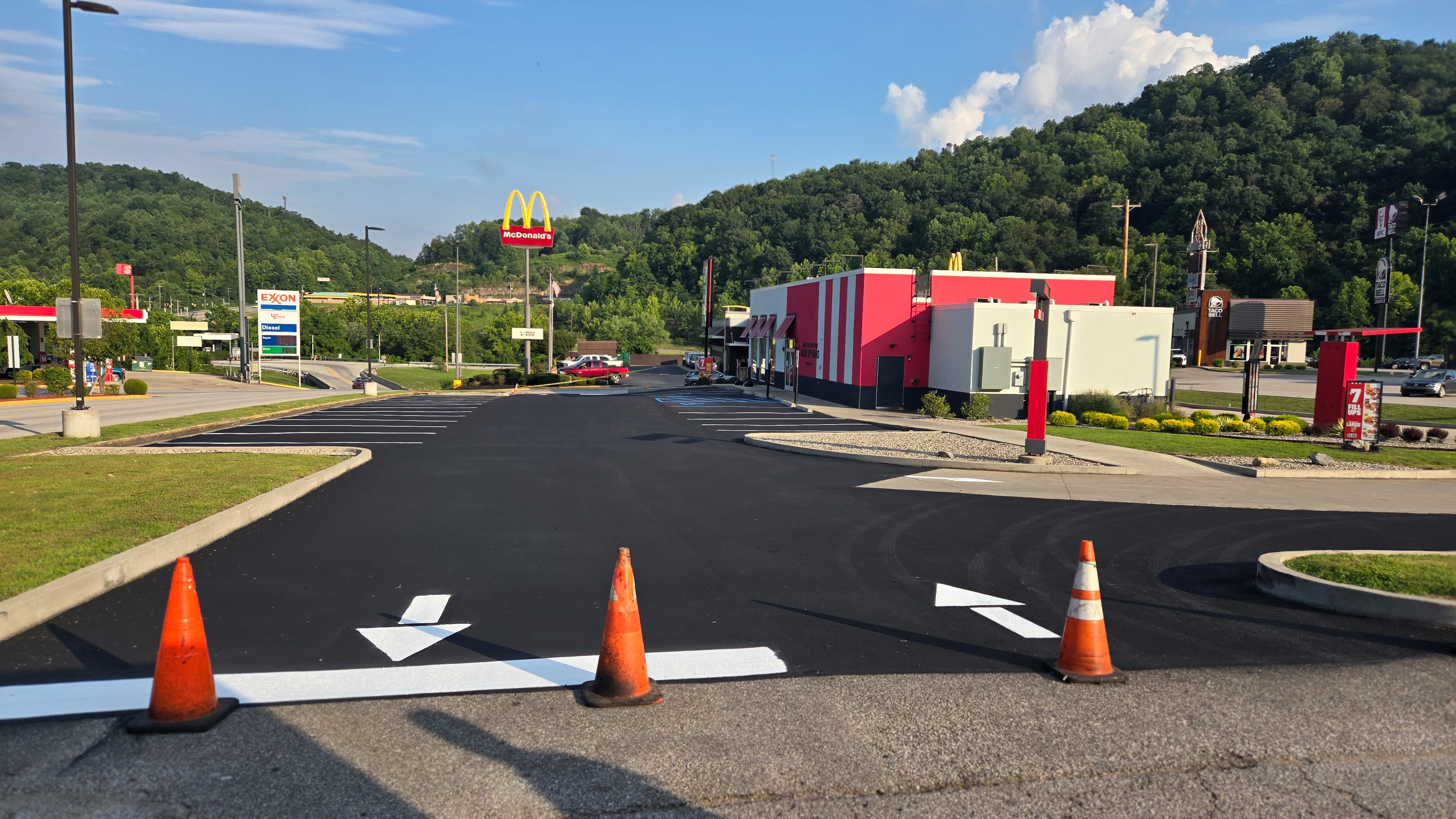 A paved parking lot in front of a Kentucky Fried Chicken restaurant.