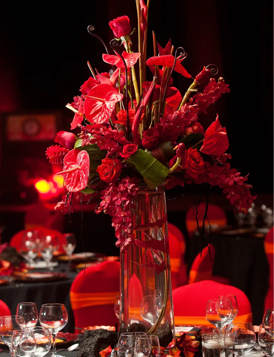 Lava-themed gala with a giant red floral centerpiece and lava rock décor by Paradym Events