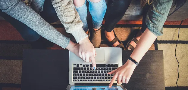 Individuals reviewing a custom event proposal on a laptop from Paradym Events