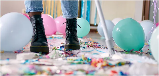 Woman sweeping up balloons and confetti after a Paradym Events celebration