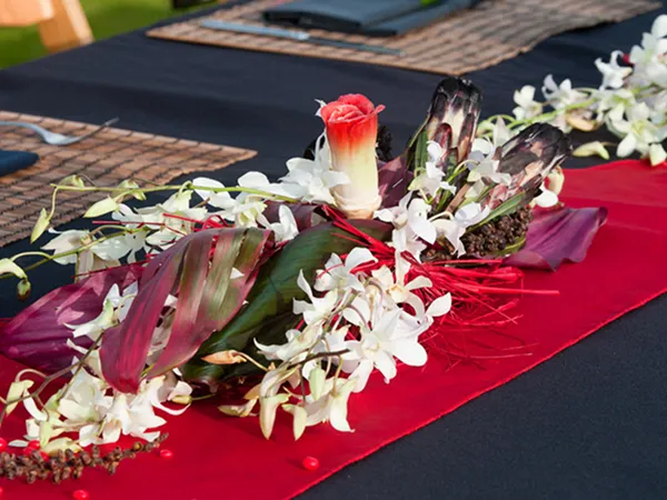 Floral centerpiece with tropical flowers and red table runner