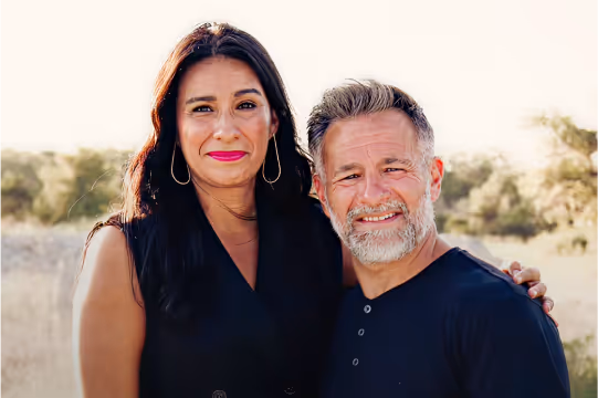 Dustin Sample smiling together with his wife outdoors, showing warmth and closeness in their marriage.