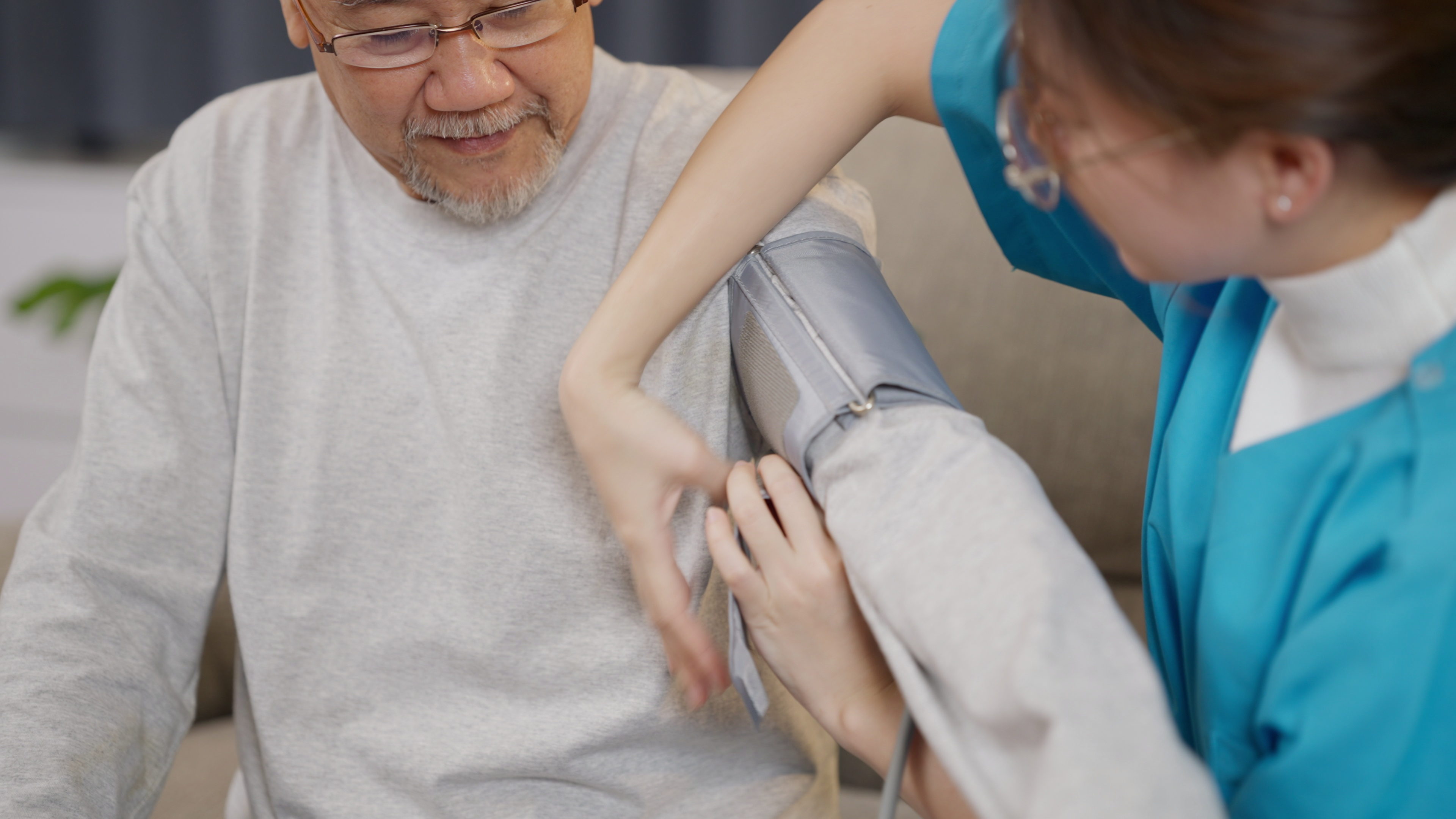 Nurse putting blood pressure monitor on patient's arm