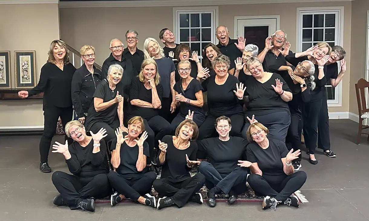 A group of volunteers dressed in black smiling at the camera.