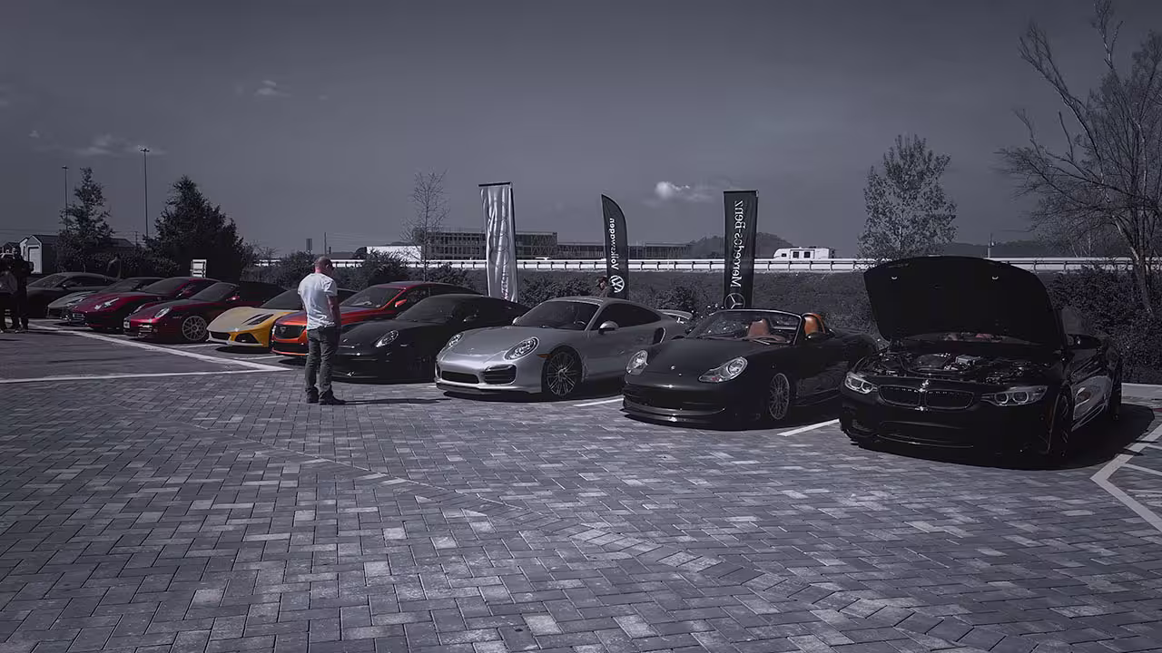 Wide-angle view of performance cars parked at Cars & Coffee outside Cooper’s Garage