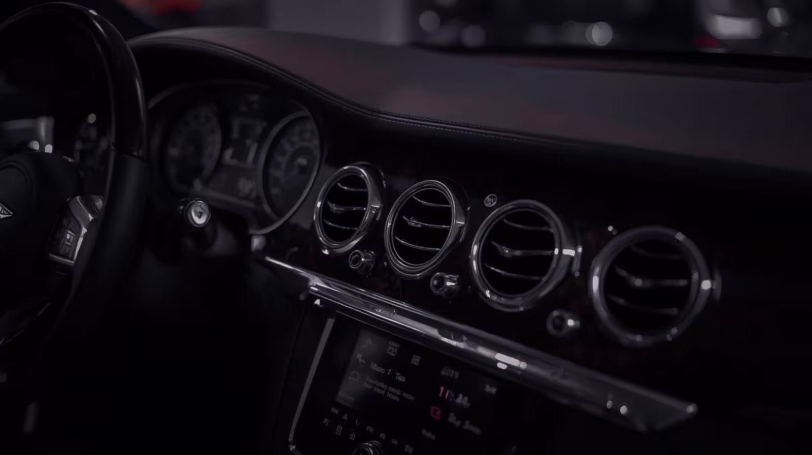 Bentley interior dashboard showing wood trim and polished chrome air vents, reflecting luxury craftsmanship