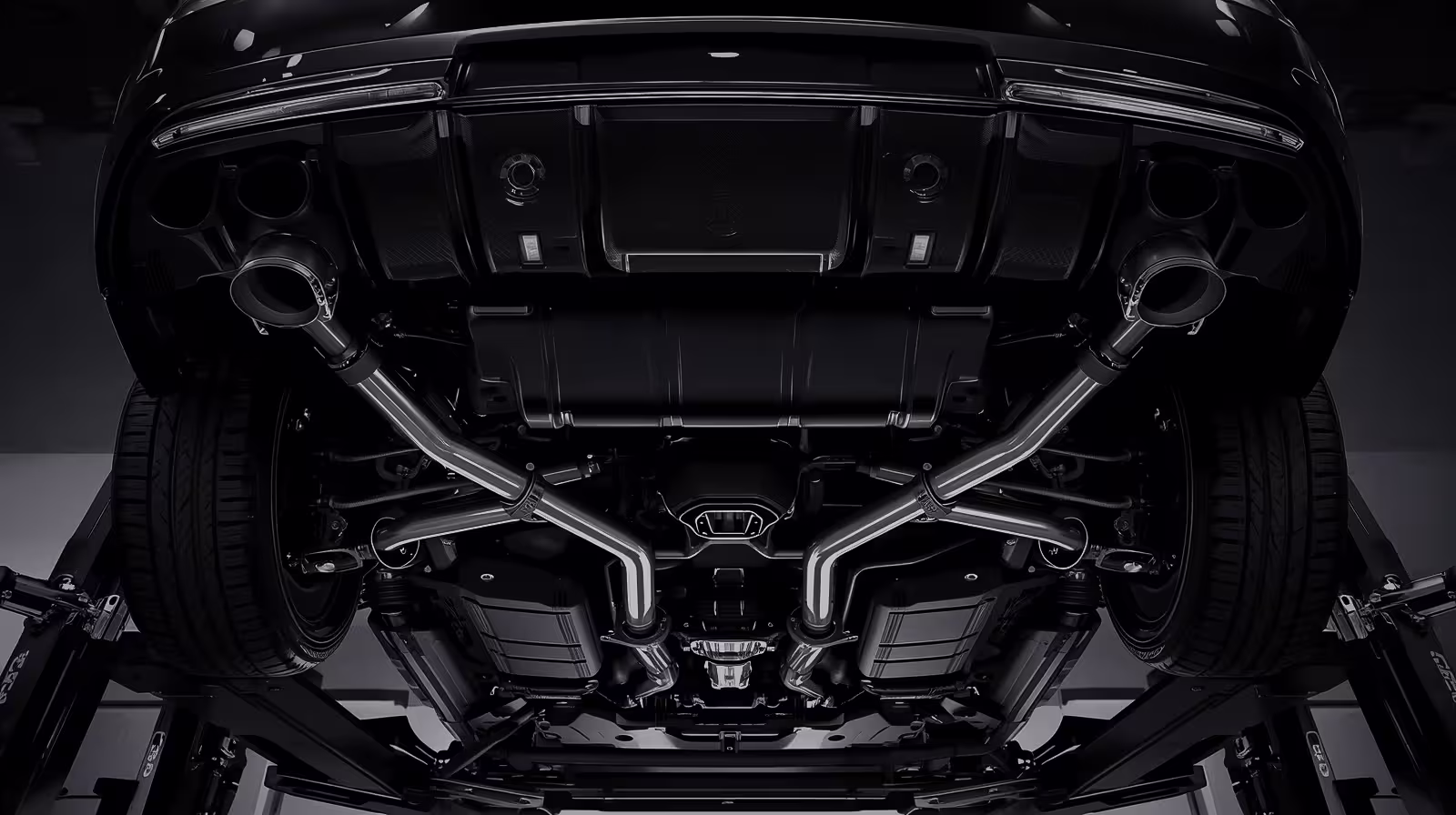 Undercarriage of a Mercedes-Benz on a lift showing Airmatic suspension and dual exhaust