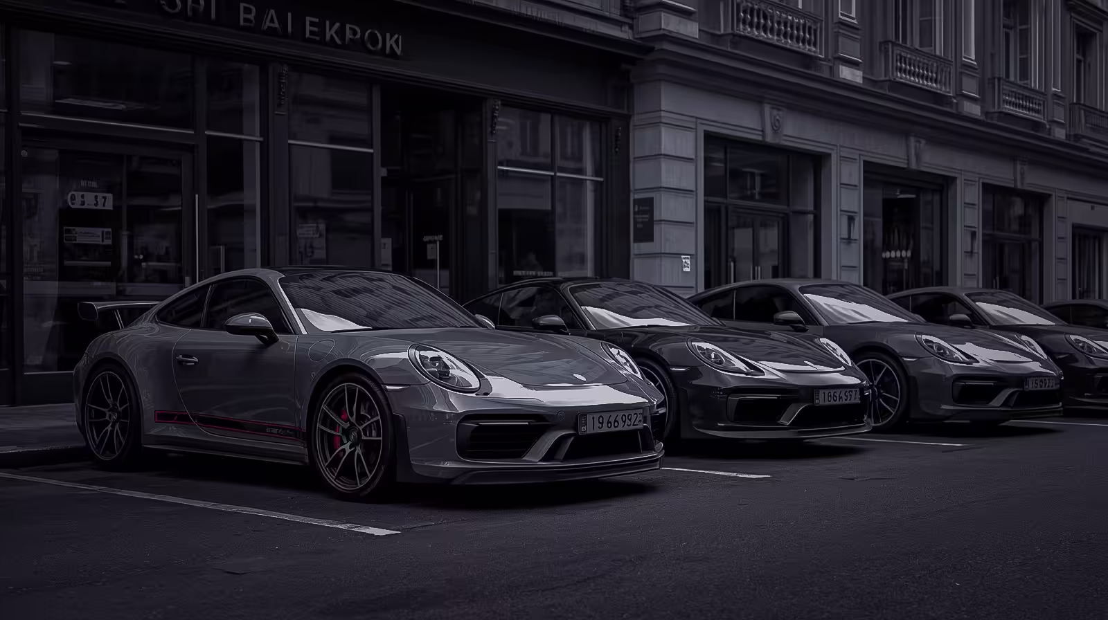 Porsche 911 and Cayenne lineup parked on city street, featuring modern performance models