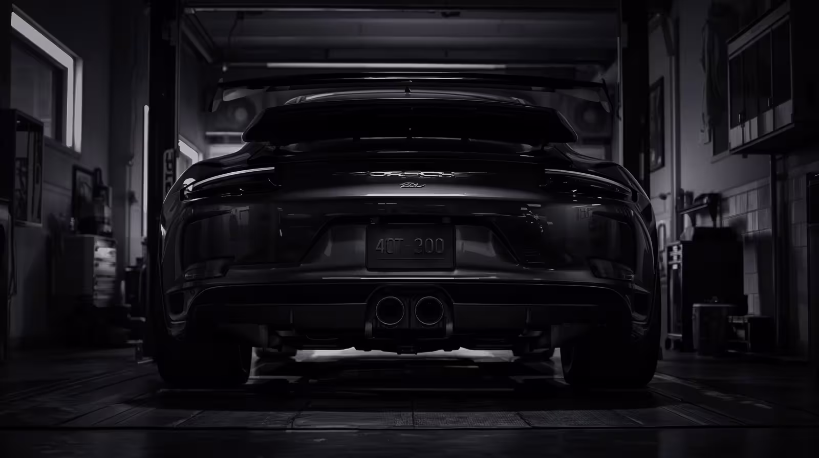 Undercarriage view of Porsche 911 on lift, showing rear-mounted drivetrain and dual exhaust system