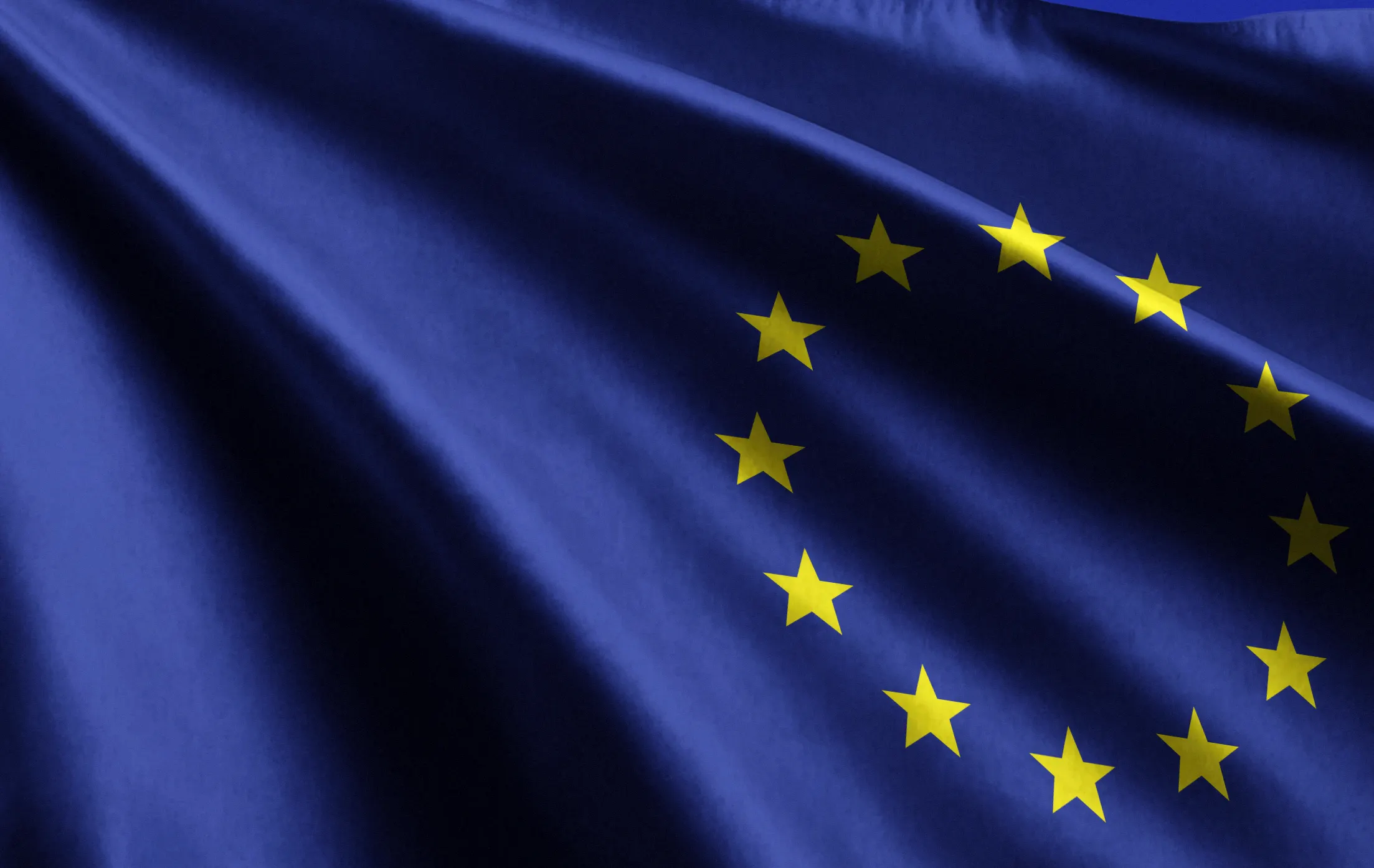 Close-up of EU flag with blue fabric and yellow stars.