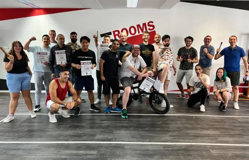 Team posing together after a company challenge event, holding certificates and props, smiling and celebrating the results.