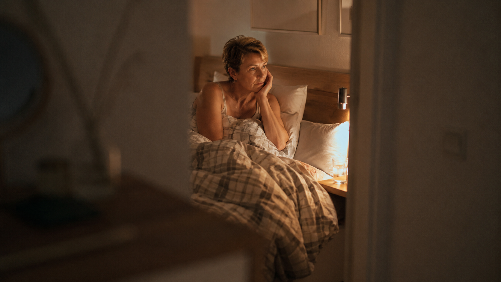 Eine Frau im Bett, die nachdenklich schaut und nicht schlafen kann