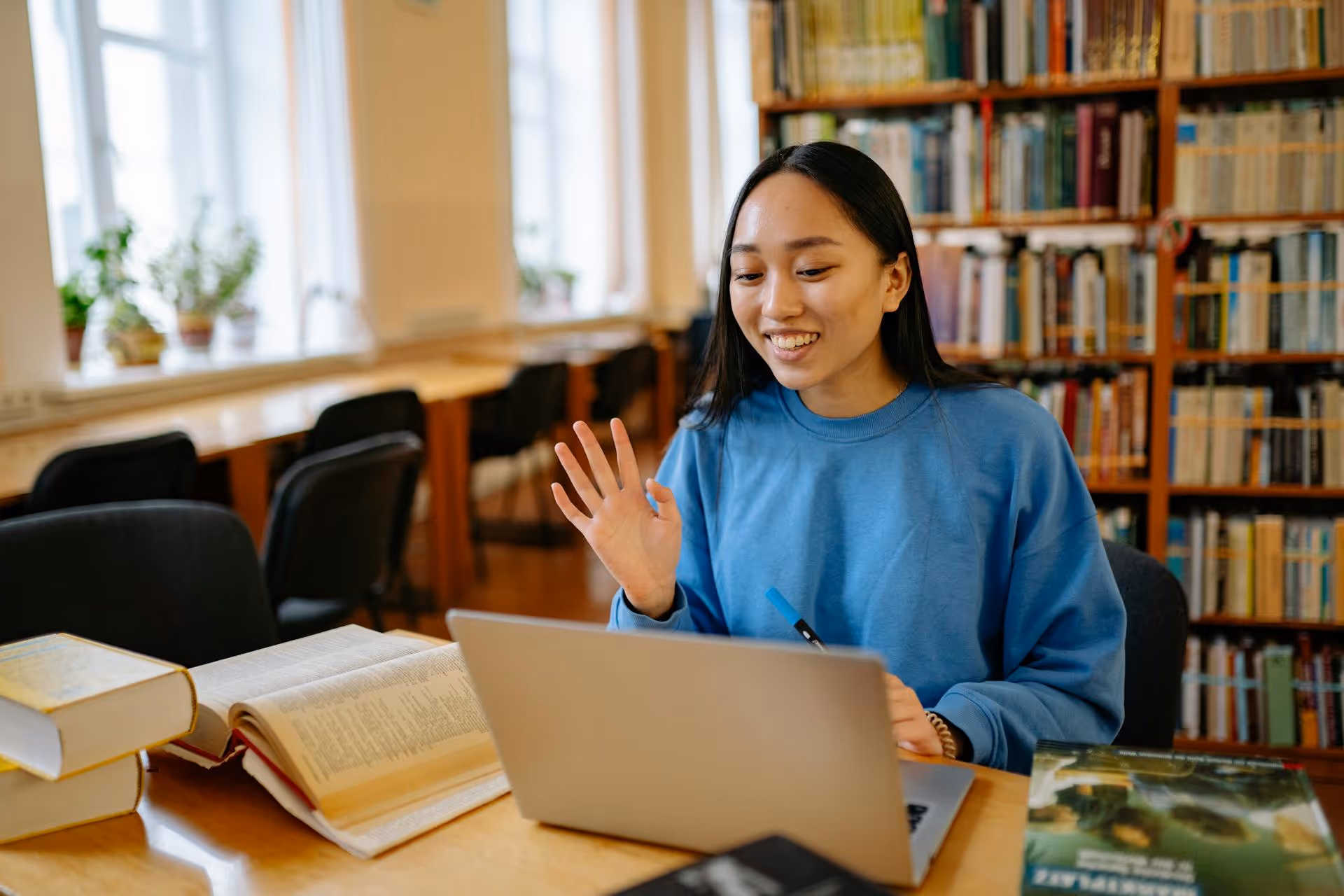 High school student waving at virtual tutor