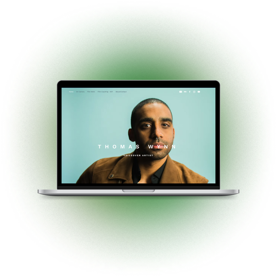 A laptop opened to "Thomas Wynn" website homepage.