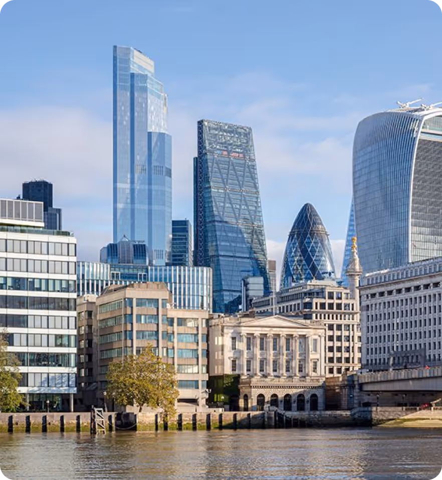 Blick auf die Londoner Skyline mit modernen Wolkenkratzern und Gebäuden am Ufer der Themse bei klarem Himmel.