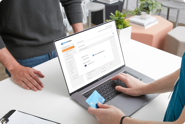 Small business owner typing credit card information into a laptop